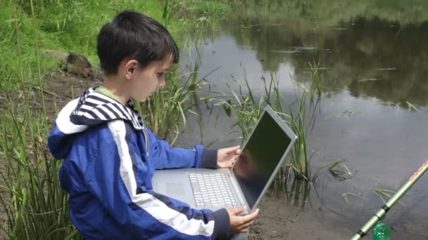 Jongen met laptop, natuur, zomer — Stockvideo