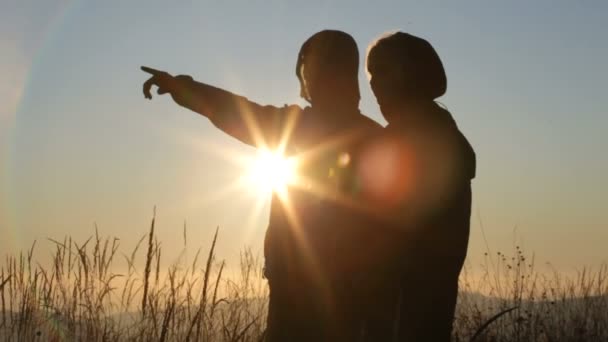 Silhuetas homem e mulher em pé nas colinas — Vídeo de Stock
