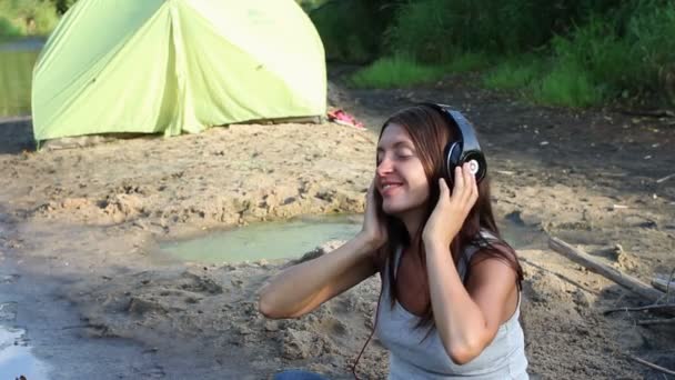 Menina com fones de ouvido por lago — Vídeo de Stock