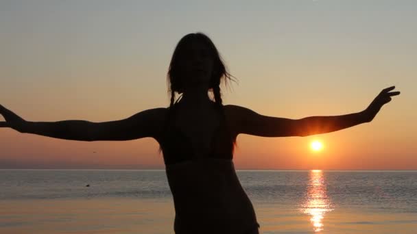 Glad kvinna dansar på stranden vid solnedgången med havet bakgrund — Stockvideo