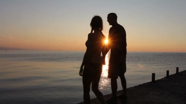 Silhouette de couple à la plage. Lumière du coucher du soleil . — Video