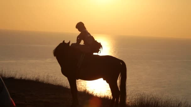 Silhouette de fille montant sur un cheval — Video