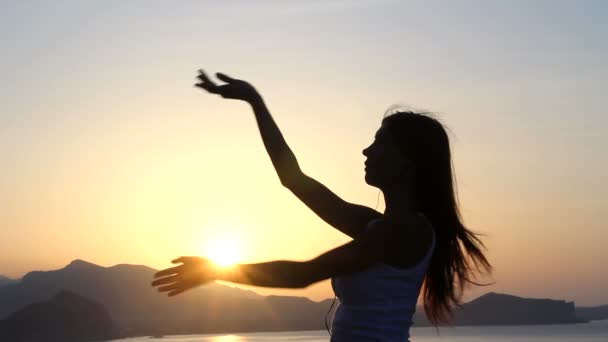 Gelukkige vrouw dansen op het strand bij zonsondergang met zee achtergrond — Stockvideo