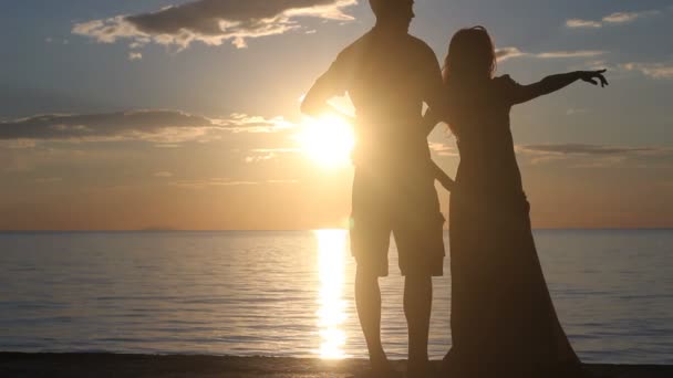 Silhouette de couple à la plage. Lumière du coucher du soleil . — Video