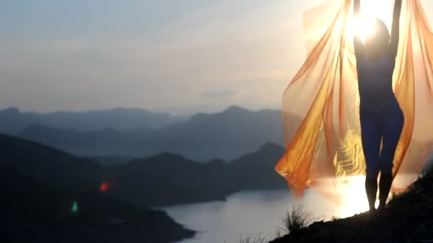 Jolie fille tenant un tissu rose dans le vent avec fond de ciel — Video