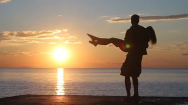 Sahilde iki siluet. günbatımı ışığı.