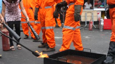 Eğitmen yangın söndürücünün nasıl kullanıldığını öğretiyor.