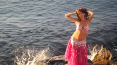 mutlu bir kadın deniz arka plan ile gün batımında sahilde dans
