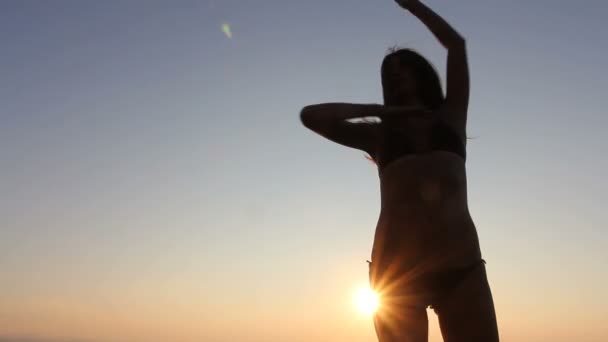 Mulher feliz dançando na praia ao pôr do sol com fundo do mar — Vídeo de Stock