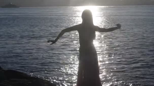 Mujer feliz bailando en la playa al atardecer con fondo marino — Vídeos de Stock