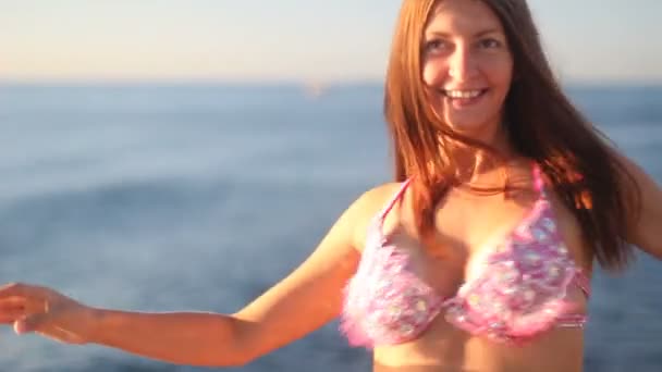 Szczęśliwa kobieta taniec na plaży o zachodzie słońca na tle morza — Wideo stockowe