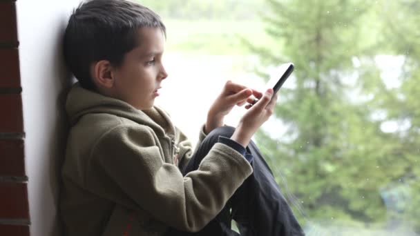 Niño usando un teléfono móvil — Vídeos de Stock