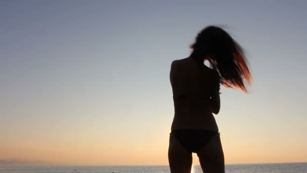 Glad kvinna dansar på stranden vid solnedgången med havet bakgrund — Stockvideo