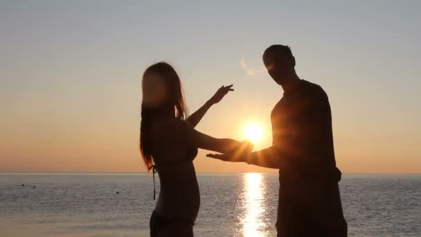 Silhouette coppia in spiaggia. Luce del tramonto . — Video Stock