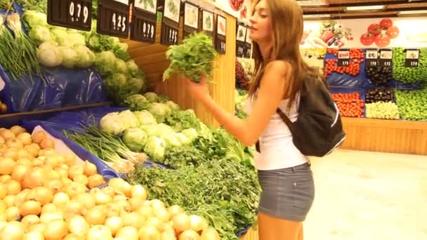 Женщина покупает овощи на рынке — стоковое видео