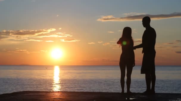 在海滩上的情侣剪影。夕阳的光辉. — 图库视频影像