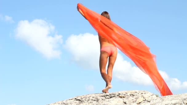 Söt flicka med rosa tyg i vind med himmel bakgrund — Stockvideo