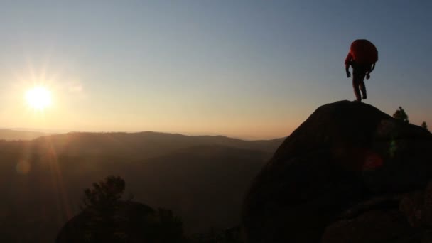 Escursionista con zaino in piedi sulla cima di una montagna — Video Stock