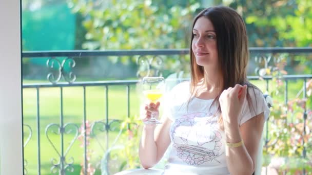 Mujer joven bebiendo un zumo de naranja — Vídeos de Stock