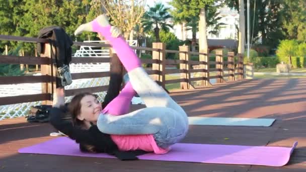 Young beautiful woman doing sports stretching exercise outdoors — Stock Video
