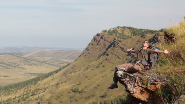 Escursionista con zaino in piedi sulla cima di una montagna — Video Stock