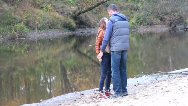 Par i höst park kram vid sjön — Stockvideo