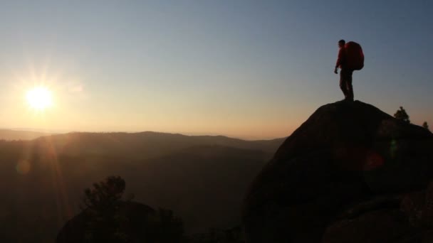 Randonneur avec sac à dos debout au sommet d'une montagne — Video