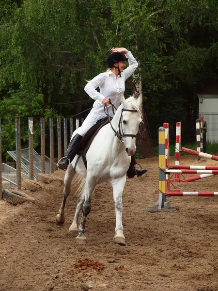 En jente som rir på en grå hest – stockfoto