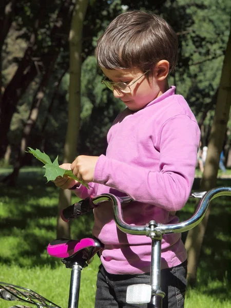 Il ragazzo nel parco con una bicicletta — Foto Stock