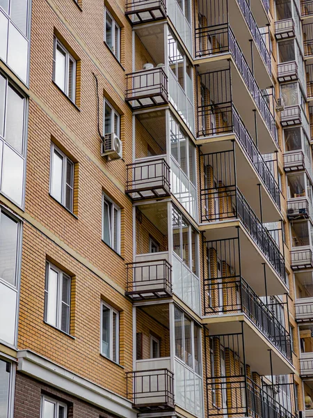 The wall of a new residential building with windows and balconies. Shooting at an angle from below.