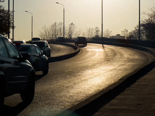 夕日の光の中で夜の道路上の車 — ストック写真