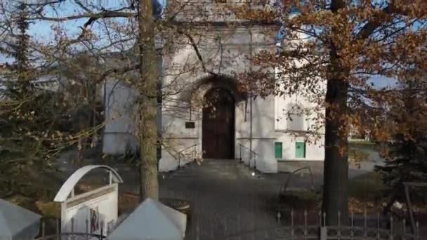 秋の木々を背景に正教会の鐘楼前を飛行する無人機 — ストック動画