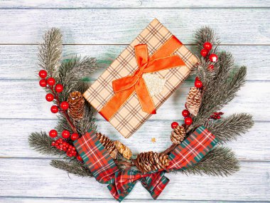 Noel çelengi, çam dalları, mandallar ve eski tahtaların üzerindeki kutular. Tatil kartı konsepti.