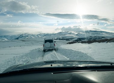 Snowy highway in the high mountains during the day. The concept of auto travel.