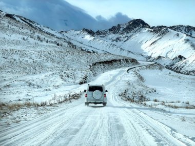 Snowy highway in the high mountains during the day. The concept of auto travel.