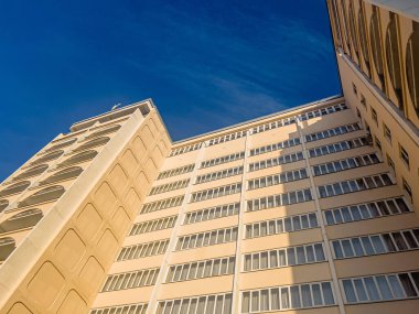 Mavi gökyüzü arka planında güzel sarı bir apartman. Konut gayrimenkul kavramı.