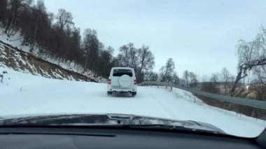 SUV öğleden sonra dağ kış yoluna tırmanır. Otomatik seyahat kavramı.
