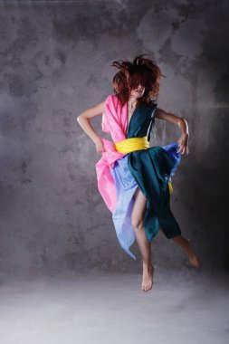 kirli grunge üzerinde renkli elbiseli genç modern dans eden kız