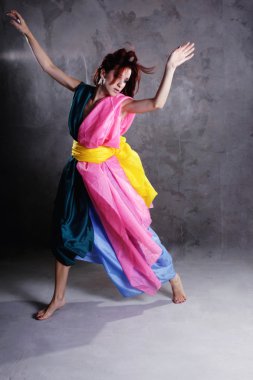 kirli grunge üzerinde renkli elbiseli genç modern dans eden kız