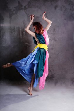 kirli grunge üzerinde renkli elbiseli genç modern dans eden kız