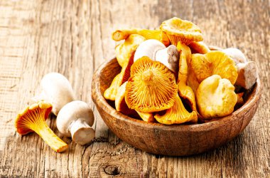 Chanterelle mantarları ve tahta arka planda şampiyon..