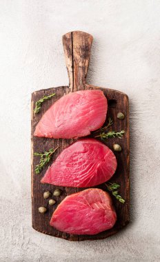 Kekikli çiğ ton balığı ve ahşap arka planda kapari..