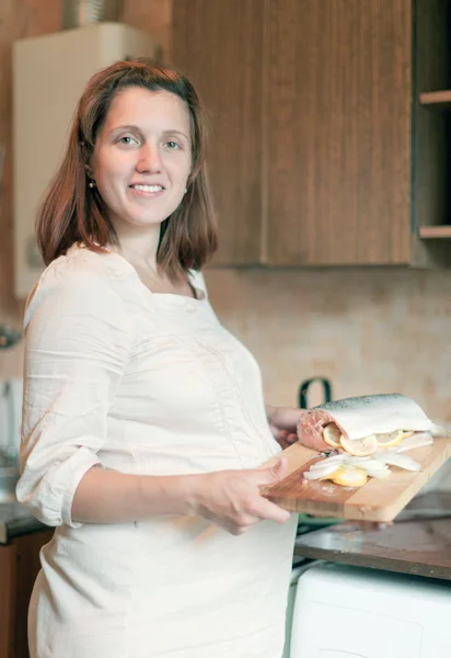 Zwangere vrouw kookt zalm — Stockfoto