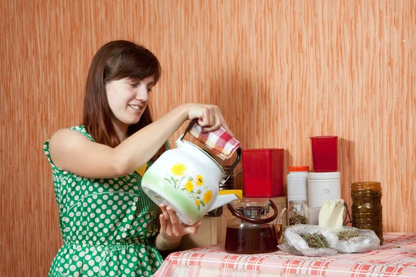 Woman brews herbs in teapot — Stock Photo, Image