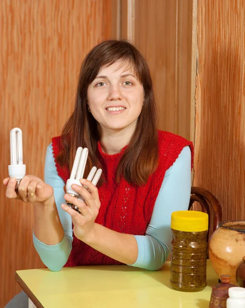 Niña sosteniendo bombillas de ahorro de energía —  Fotos de Stock