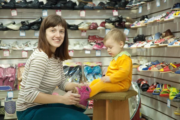 Мати з дитиною вибирає дитяче взуття — стокове фото