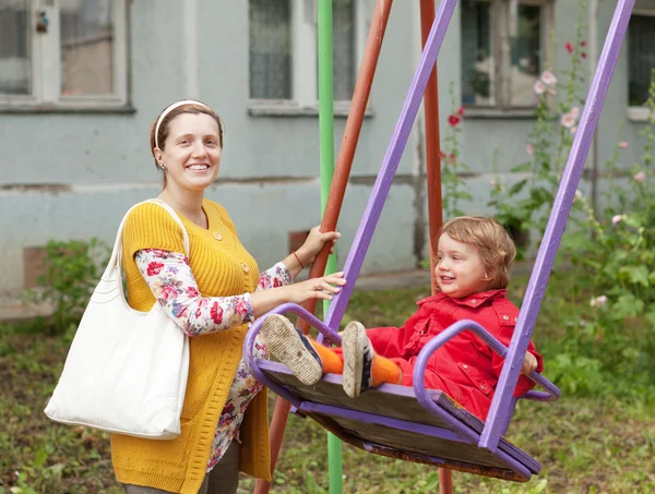 Pregnant woman with child on swing — Stock Photo, Image