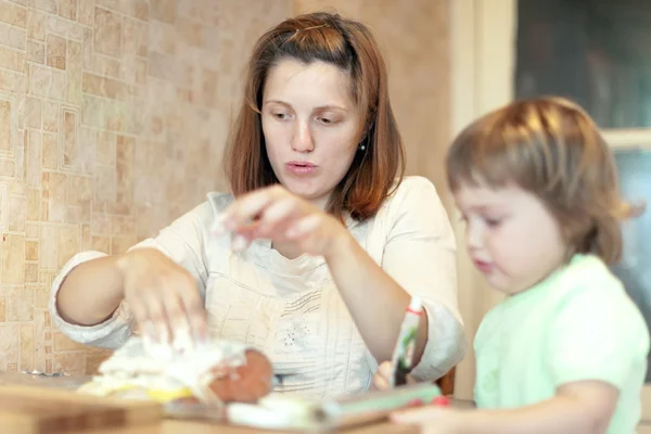 Glad mamma med dotter matlagning lax i folie — Stockfoto