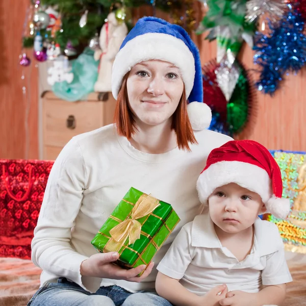 Chłopiec i matka w santa hat — Zdjęcie stockowe