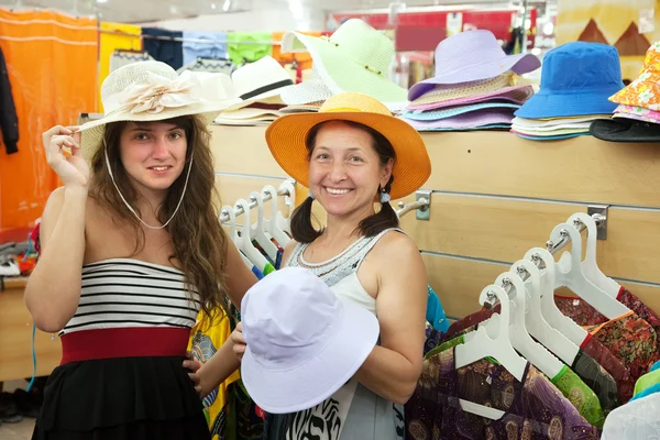 Mulheres escolhem chapéu na loja — Fotografia de Stock